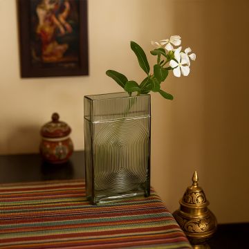 Smoky gray rectangular glass vase with embossed circular texture styled in a modern interior for a minimal elegant look.