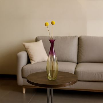 Elegant gradient glass vase in purple and yellow tone placed on table for modern home and living room decor.