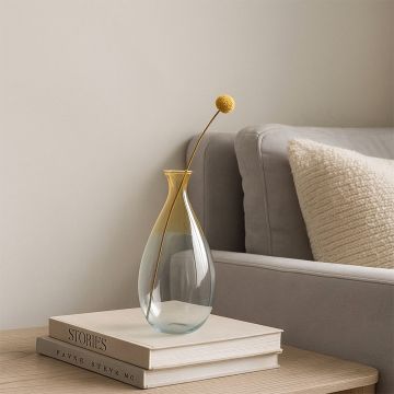 Elegant yellow gradient glass vase placed on table adding modern charm to home and living room decoration.