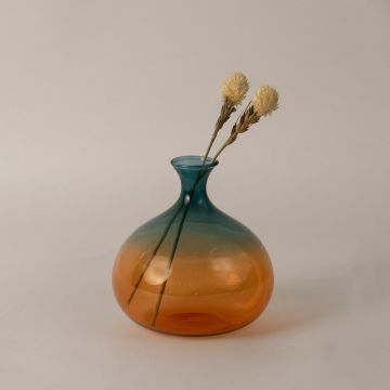 Elegant teal and amber gradient glass vase placed on table adding charm to modern home interior decoration.