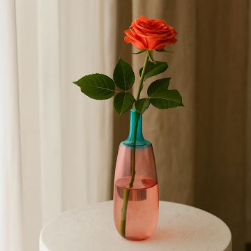 Elegant pink and blue gradient glass vase placed on table adding charm to modern home and living room decor.