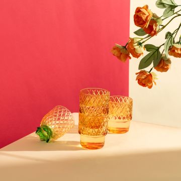 Set of pineapple shape glass tumblers with diamond cut pattern in amber color ideal for serving drinks in modern homes.