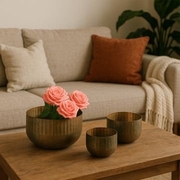 Ribbed metal bowl planter styled in a warm modern space adding a rustic touch to shelves and decor corners.