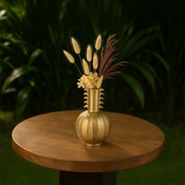 Golden decorative vase styled in a modern lifestyle setting showcasing its sculpted neck detailing and round textured base