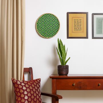 Handcrafted bamboo wall plate with green geometric weave design adding earthy charm to living room or hallway walls.