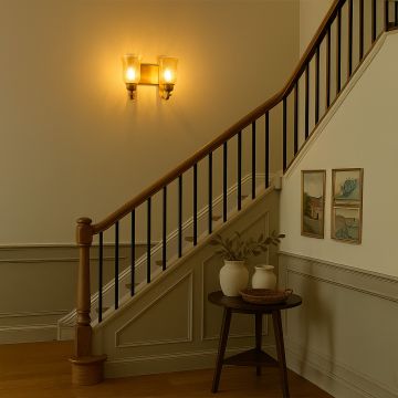 Dual brass wall sconces with amber crackle glass shades illuminated on wall creating elegant symmetrical traditional home lighting.