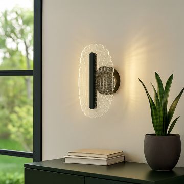Black metal wall light with clear acrylic decorative shade adding soft ambient lighting to a modern home interior.