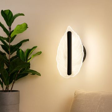 Black wall light with leaf shaped acrylic shade adding soft ambient lighting to a modern stylish home interior.