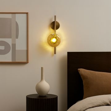 Gold wall light with amber textured glass shade adding warm ambient lighting to a modern elegant interior.