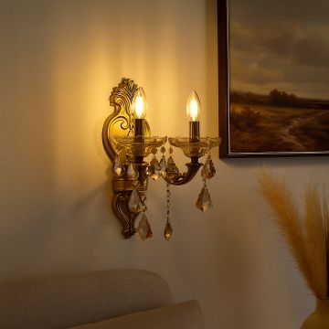 Luxury 2 light gold wall light with crystal drops glowing warmly in living room interior for elegant home decor.