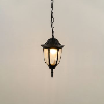 Black hanging lantern on white background with light on showing glowing curved glass panels and classic metal top ideal for outdoor ceiling and porch lighting.