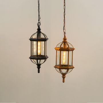 Pair of outdoor pendant lanterns in black and antique brass finishes hanging together with warm lights on against a white background.
