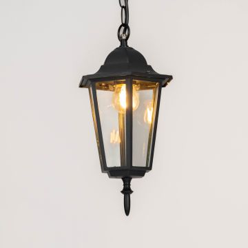 Elegant black hanging lantern with glass panels glowing warmly on white background ideal for outdoor ceiling lighting.