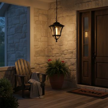 Black hanging outdoor lantern with light on illuminating a cozy porch with stone wall wooden door and chair creating a warm inviting evening ambiance for home exteriors.