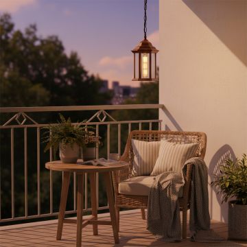 Copper hanging outdoor lantern with light on illuminating a cozy balcony seating area creating a warm inviting glow for evening relaxation and exterior decor enhancement.