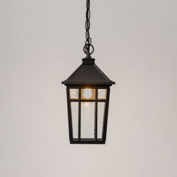 Illuminated black metal hanging lantern with clear glass panels and warm LED bulb glowing on clean white background.