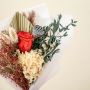 Elegant Infinity Rose Red bouquet in hand featuring preserved hydrangea eucalyptus pampas grass and lotus pod perfect for weddings gifts and home decor.