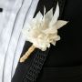 Detailed view of white artificial flower boutonniere with jute wrap – groom wedding accessory floral design.