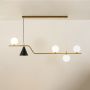 A modern linear chandelier with gold and black accents and glowing white globes hanging against a soft beige background creating elegant warm contemporary décor.