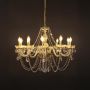 Crystal chandelier with gold base illuminated against black background showing luxury lighting design.