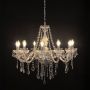 Elegant chandelier with crystal detailing and silver finish illuminated against black background for luxury decor.