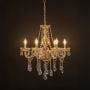 Elegant chandelier with gold detailing and crystal glass droplets illuminated against black background decor.