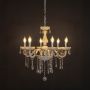 Elegant white chandelier with crystal details illuminated against black background for luxury home lighting.