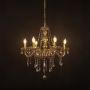 Elegant golden chandelier with crystal accents illuminated against black background for modern decorative style.