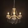 Elegant white chandelier with crystal accents illuminated against black background for modern decorative lighting.