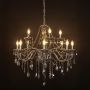 Elegant chandelier with smoky crystal and silver finish illuminated against black background for modern decor.