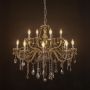 Elegant chandelier with golden crystal finish illuminated against black background for stylish home lighting.