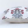 Soft cotton cushion cover with detailed red and blue floral embroidery shown at an angle offering a vibrant nature inspired décor accent with a breathable gentle and skin friendly fabric finish.