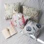 Soft cotton cushion covers in assorted floral designs arranged on a bed offering a cozy nature inspired décor setting with breathable gentle and skin friendly fabrics ideal for home styling.