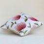 Soft cotton cushion cover with bold red floral embroidery placed at an angle adding a bright nature inspired décor touch with a breathable smooth and skin friendly fabric texture.