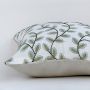 Soft cotton cushion cover with green leaf embroidery shown at an angle offering a fresh nature inspired décor accent with a breathable gentle and skin friendly fabric finish ideal for modern homes.
