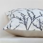 Closeup of the cushion showing the fine stitched grey branches and textured fabric detail.