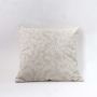 Decorative beige cushion cover with elegant white leaf embroidery on plain white background.