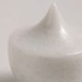 Detailed closeup of a white ceramic decor piece featuring a unique pointed design with smooth glossy surface texture.