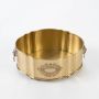 A brass fruit bowl displayed on a clean white background highlighting its engraved motif raised legs and elegant shape designed to hold fruits or decor items.