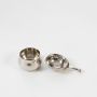 Top view of the silver plated tea strainer and matching drip bowl resting side by side on a clean white background.