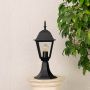 Outdoor black pillar lamp placed on stone pillar with light off adding timeless elegance to home garden and entrance decor.