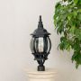 Classic outdoor black pillar lamp with rounded glass shade placed on stone pillar perfect for terrace and entrance decor.
