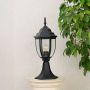 Classic outdoor black pillar lamp with transparent glass shade placed on stone pillar perfect for villa entrance decor.