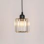 Glass pendant light with black metal fixture glowing warmly against plain white background.