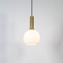 Globe pendant light turned on with frosted glass shade and brass holder displayed on clean white background.