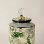 Closeup of tropical bird jar showing detailed artwork of tropical plants & birds and fine ceramic texture.