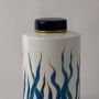 Closeup of ceramic decor jar showing detailed blue wave artwork with smooth glossy finish and golden accent lid.