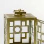 Closeup of brass lantern showing intricate metalwork and candle inside for luxurious lighting decor.