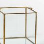 Cube closeup showing clear glass panels with gold metal frame perfect as decorative storage box for modern interiors.