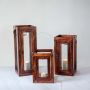Set of handcrafted wooden glass lanterns in different sizes with metal handles perfect for home and garden decor.